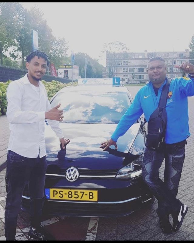 Instructeur en geslaagde leerling bij de lesauto
